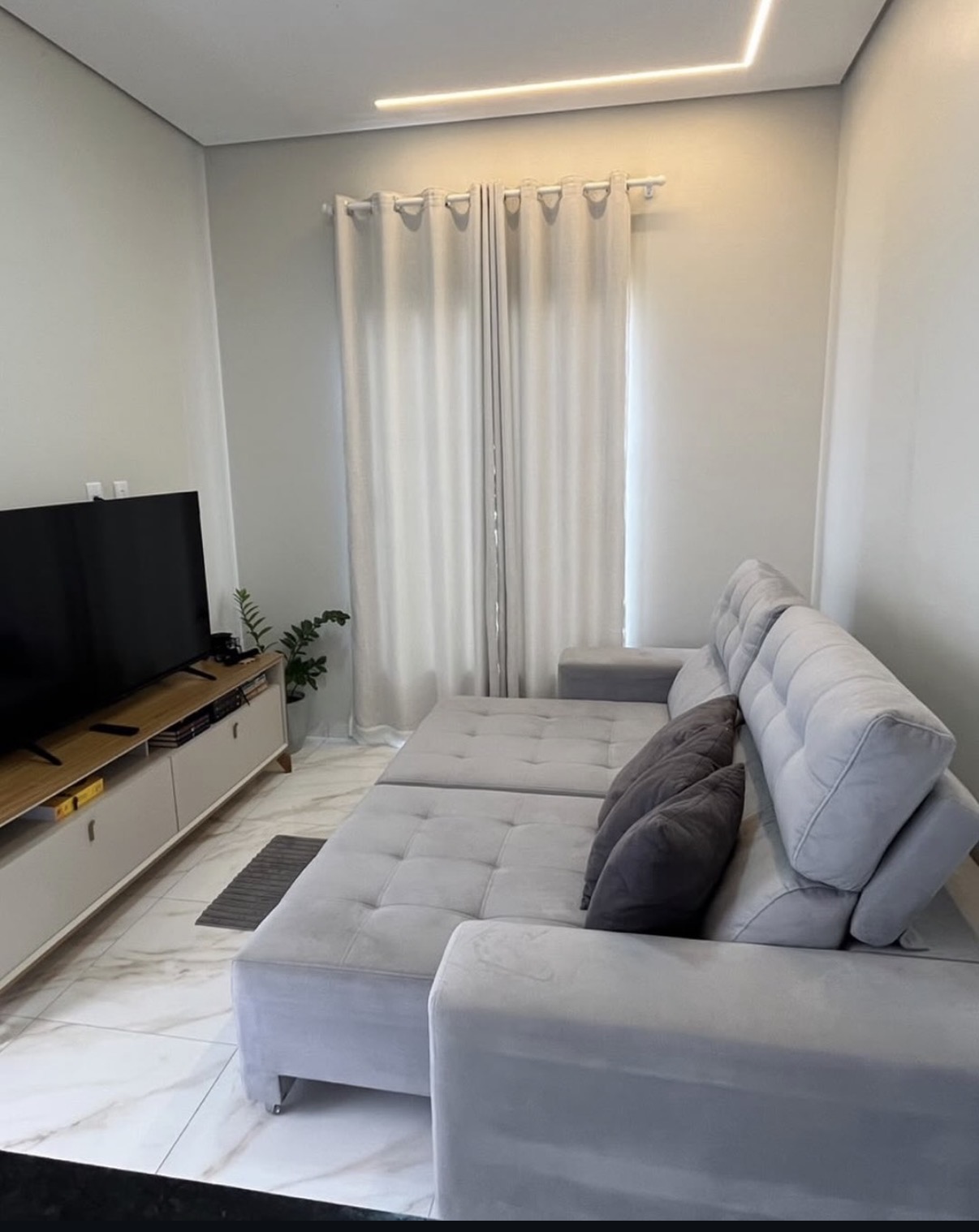 Sofá cinza-claro com chaise em sala de estar
